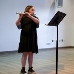 A person playing a wind instrument reading music